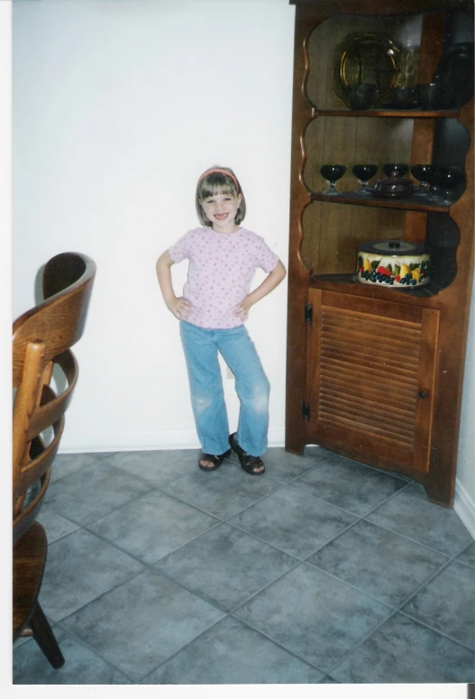 a small girl in front of a cabinet