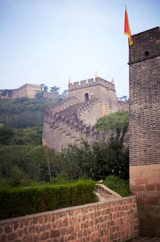 the view of the building on top of a hill with trees and bushes