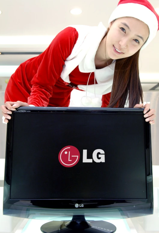 a woman holding up a large lg monitor