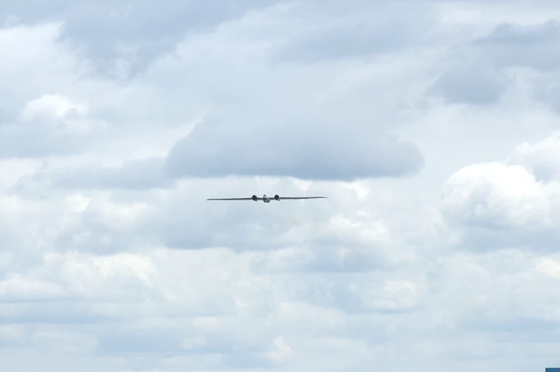 an airplane flying low in the sky on a cloudy day