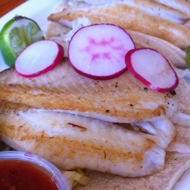 a dish of fish and vegetables with sauce