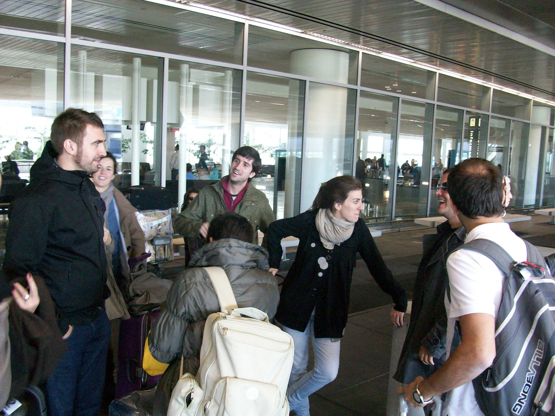 several people walking into an airport to board