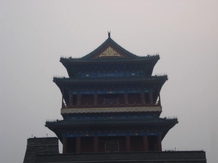 a large clock tower near a wall with a building on top