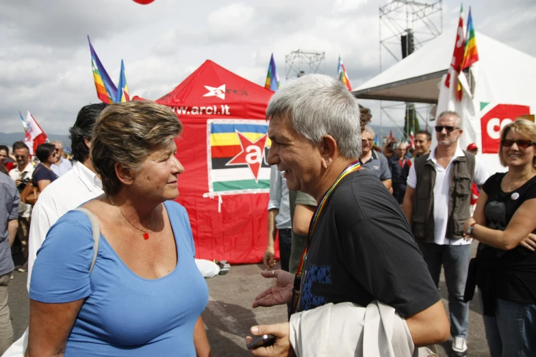 a man is talking to a woman near many flags