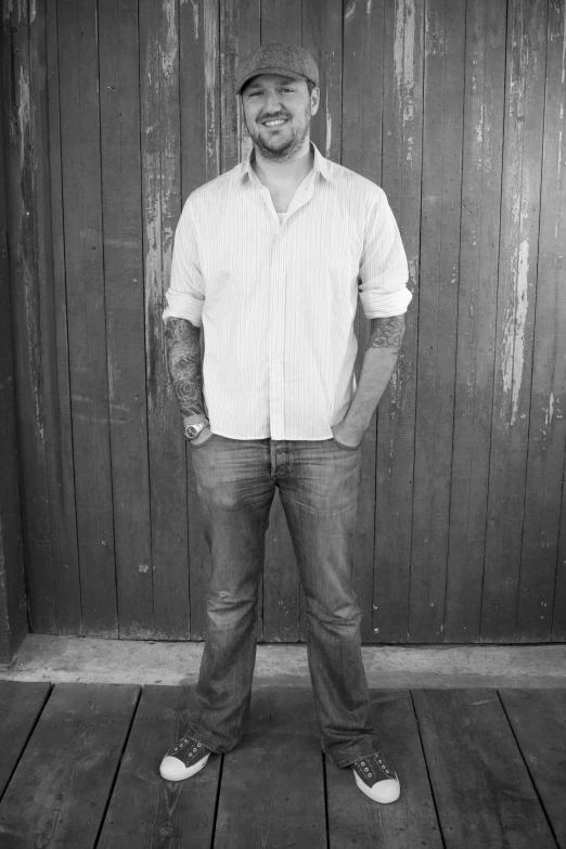 a man standing in front of a wooden wall