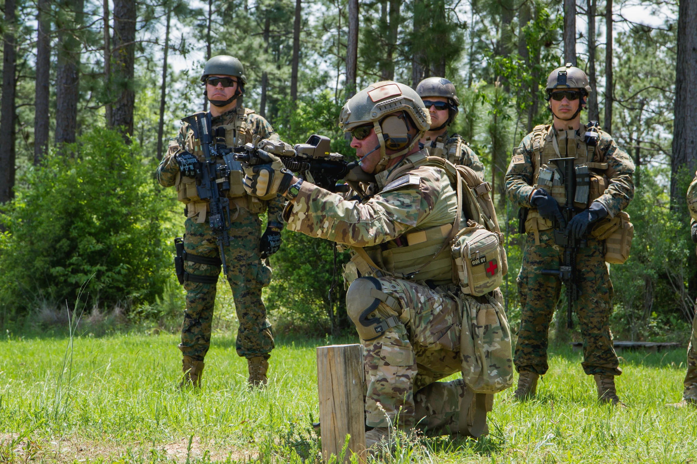 four soldiers are crouching down with guns in their hands