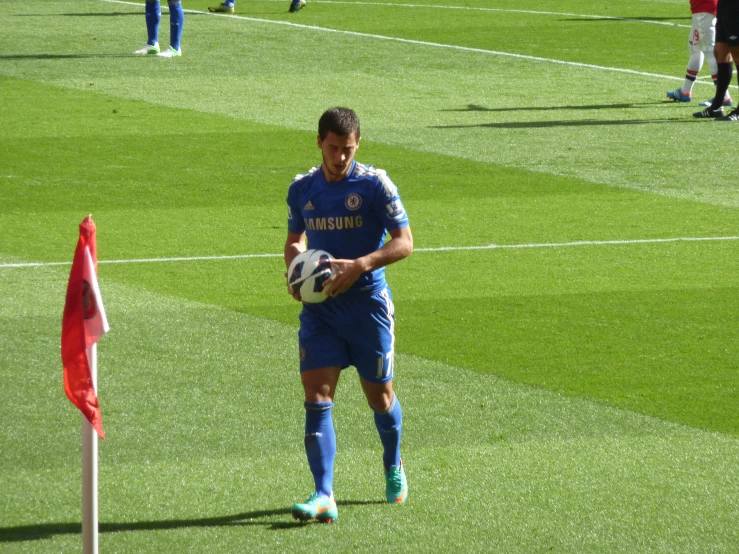 a male soccer player holding a ball on a field
