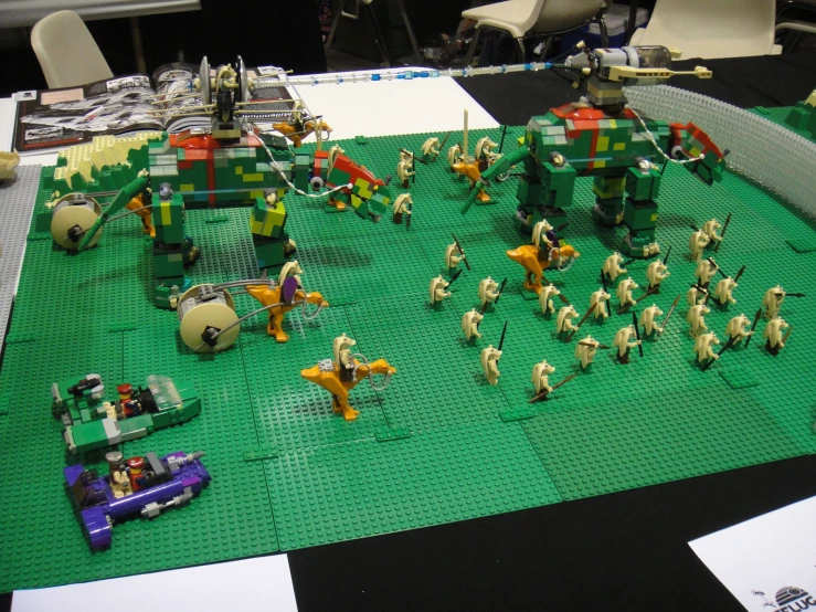 some people on green lego set with one figurine