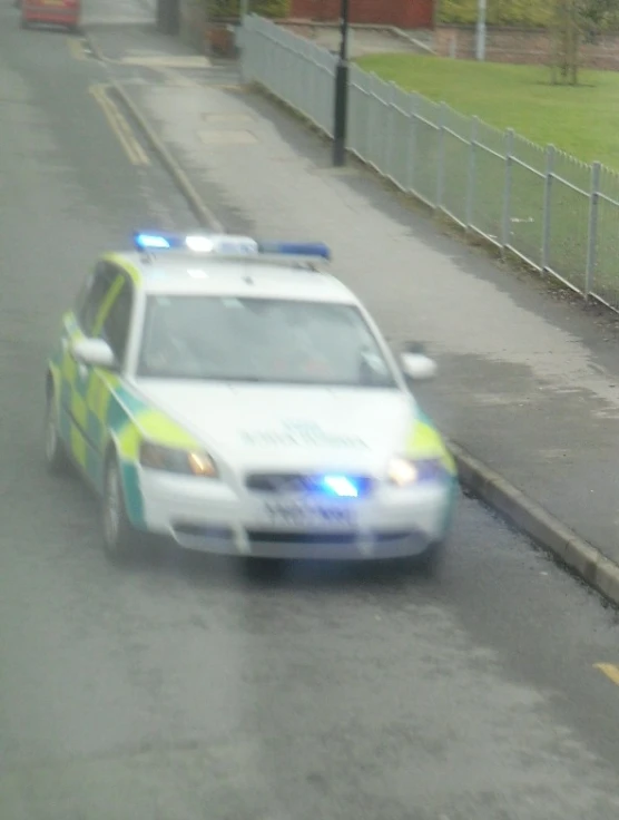 a police car driving down the road behind a guard rail