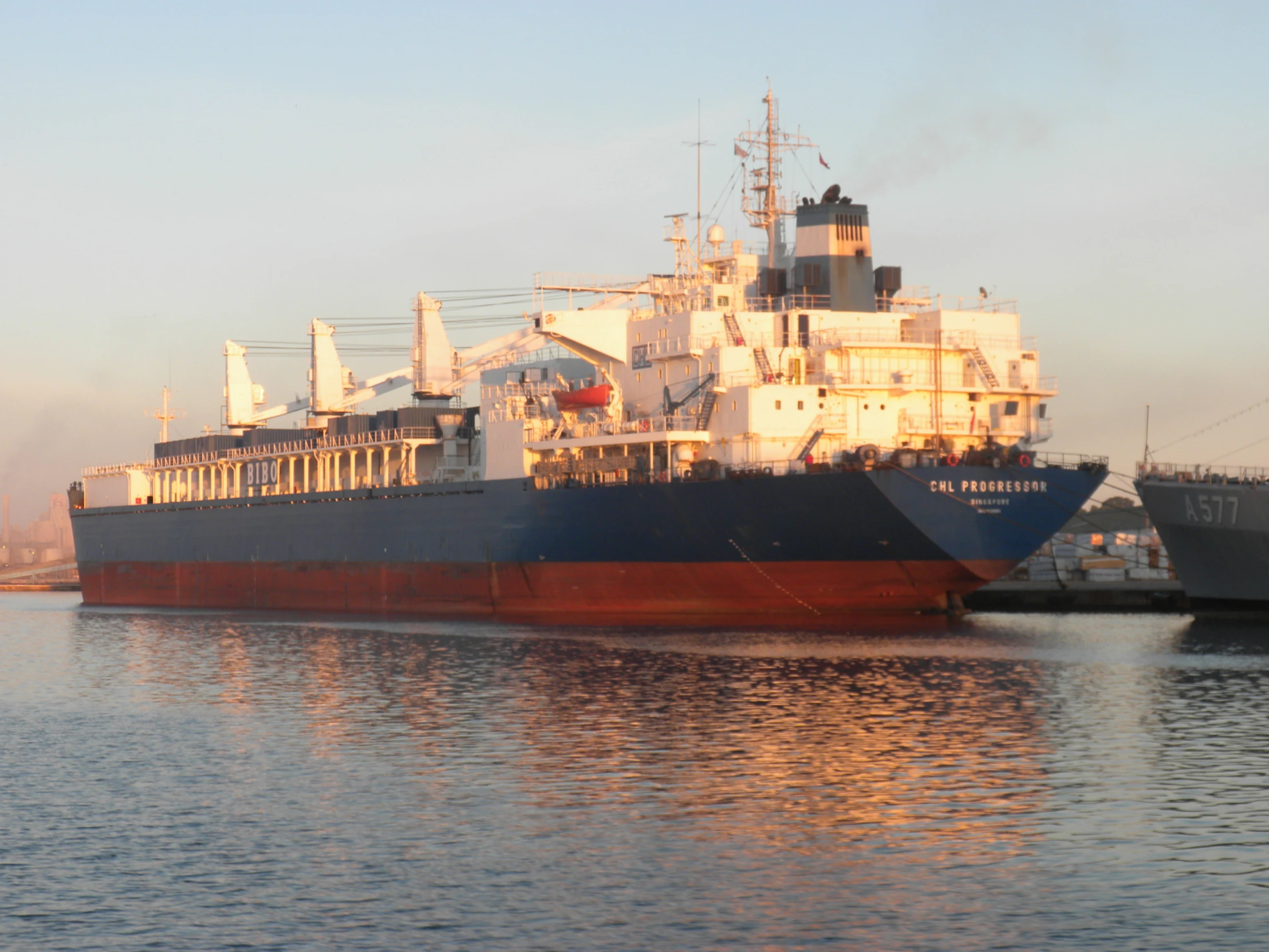 the large, white ship is being hed by two smaller ships