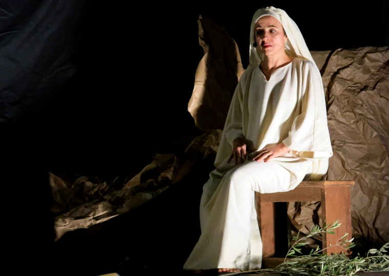 a woman in a white dress sitting on top of a chair