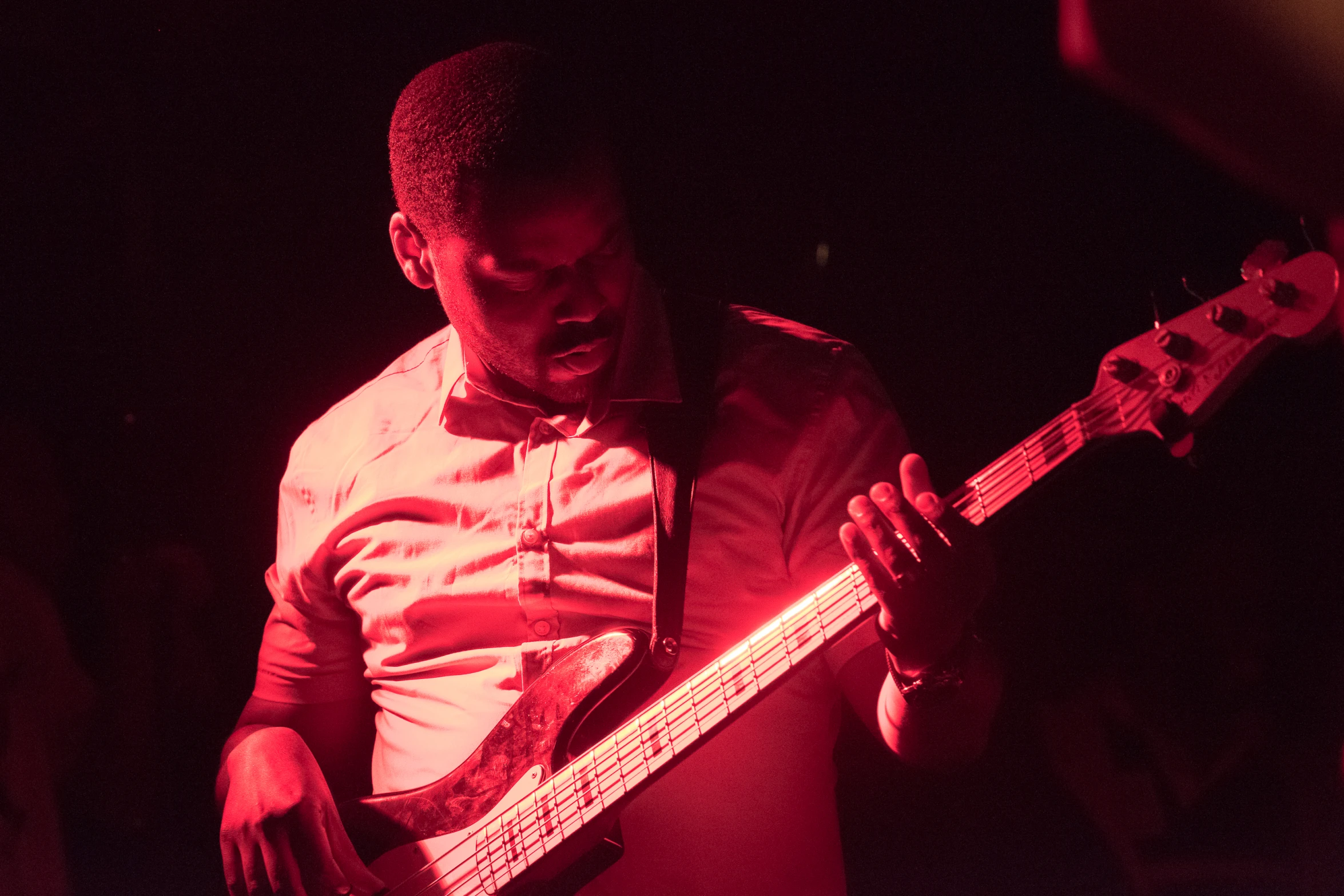 a man in white shirt and tie playing guitar