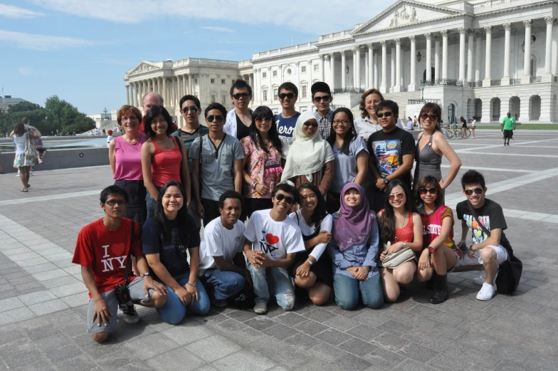 group of people posing in front of an old building