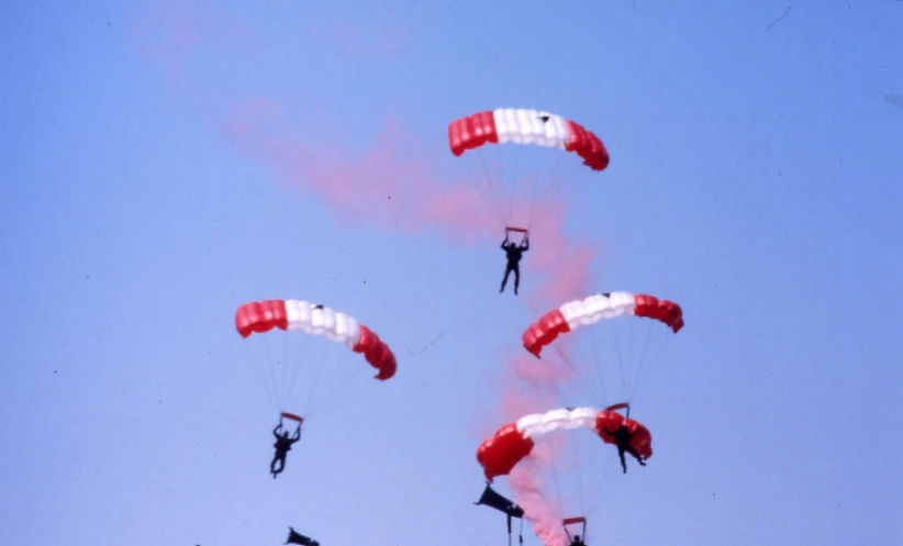 people in the air doing a stunt with parachutes