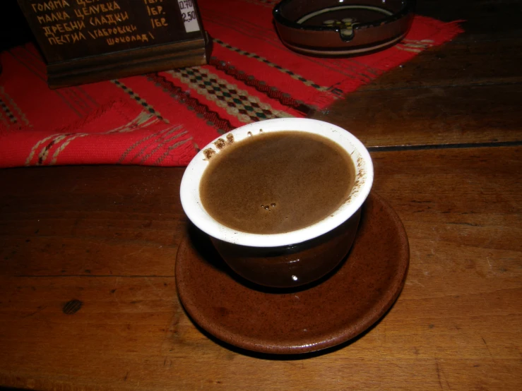 a brown table with a small cup on it and two pos