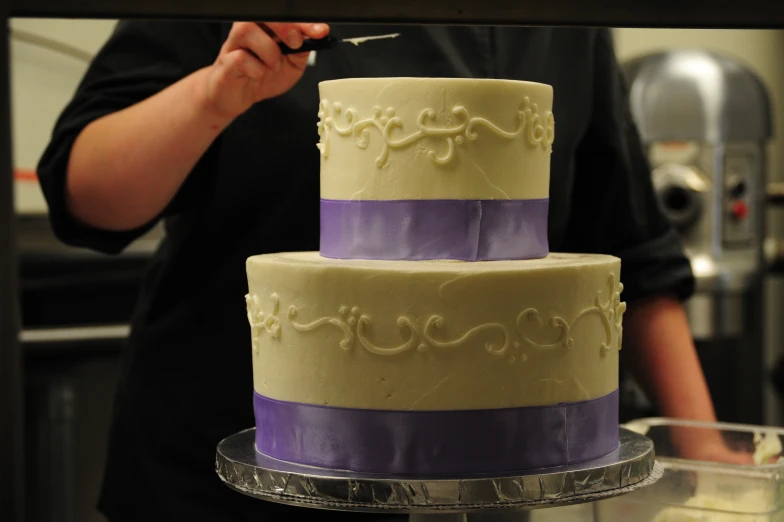 a three - tiered cake sitting on a clear cake plate