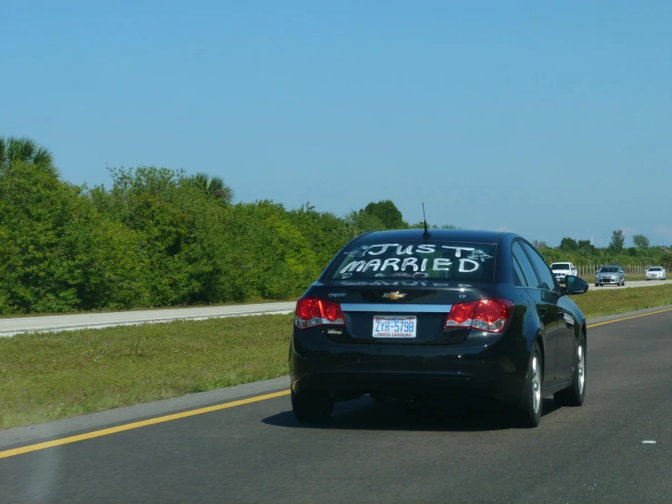 a vehicle with a sign on its back traveling down the road