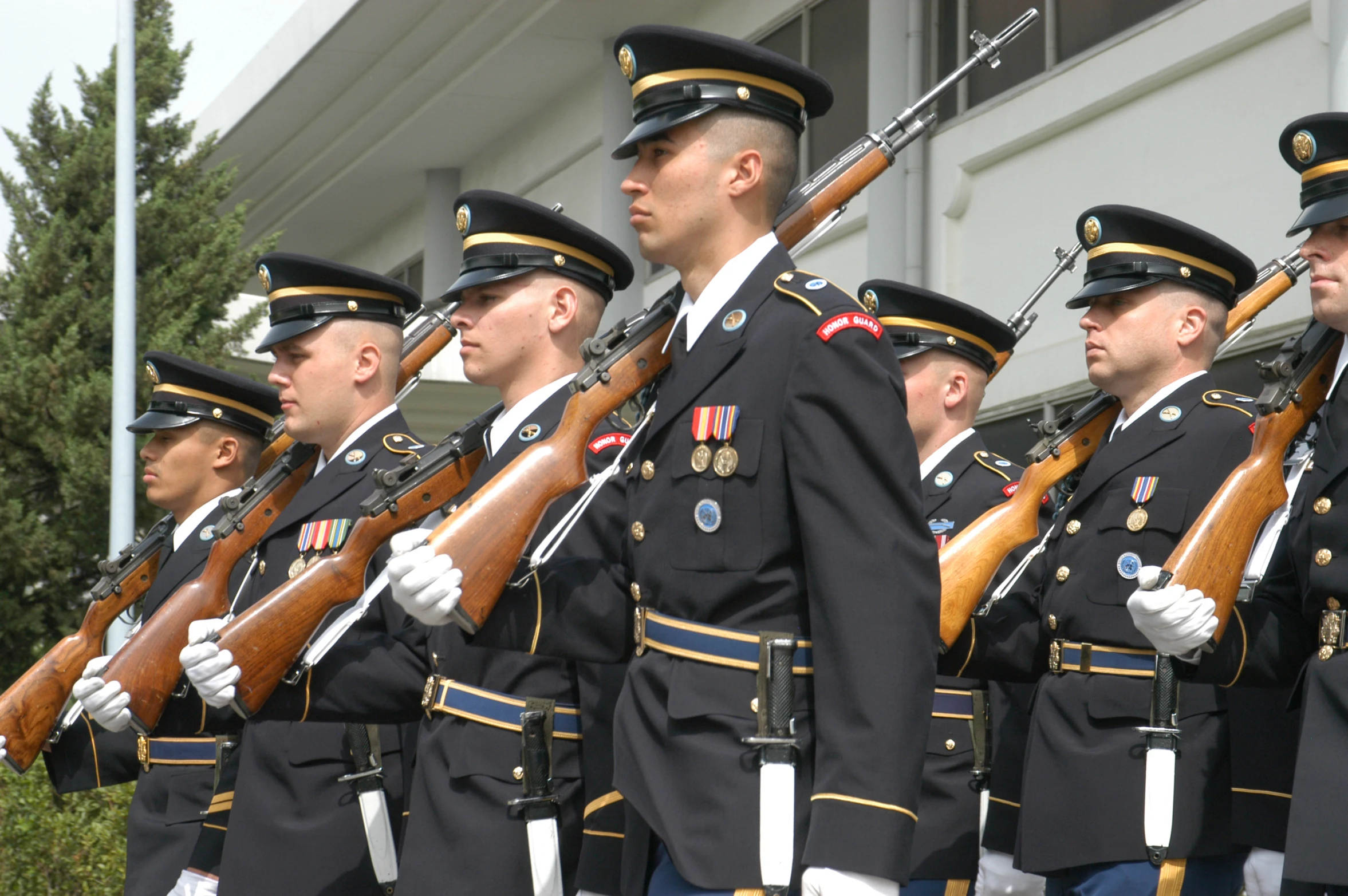 there are several people in uniform marching and holding guns