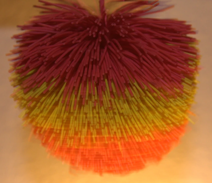 a colorful object on display with lots of threads
