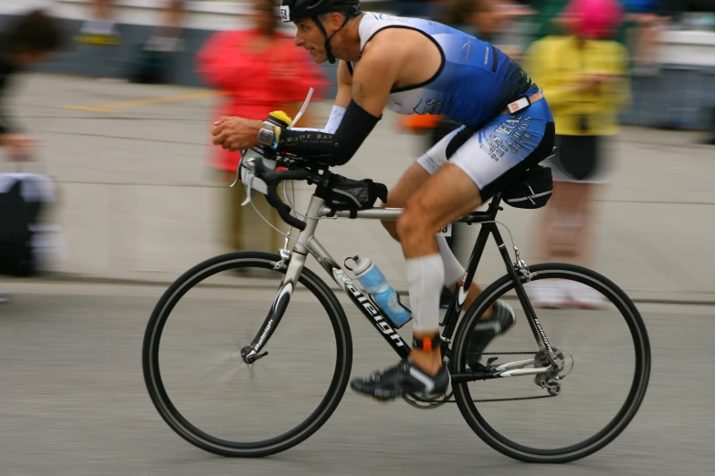 a man riding on the back of a bike down a street