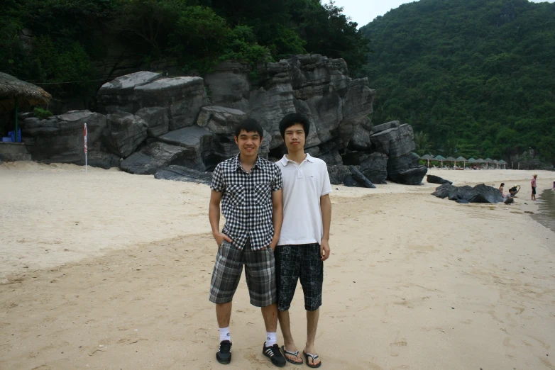 a  standing next to another guy on a beach