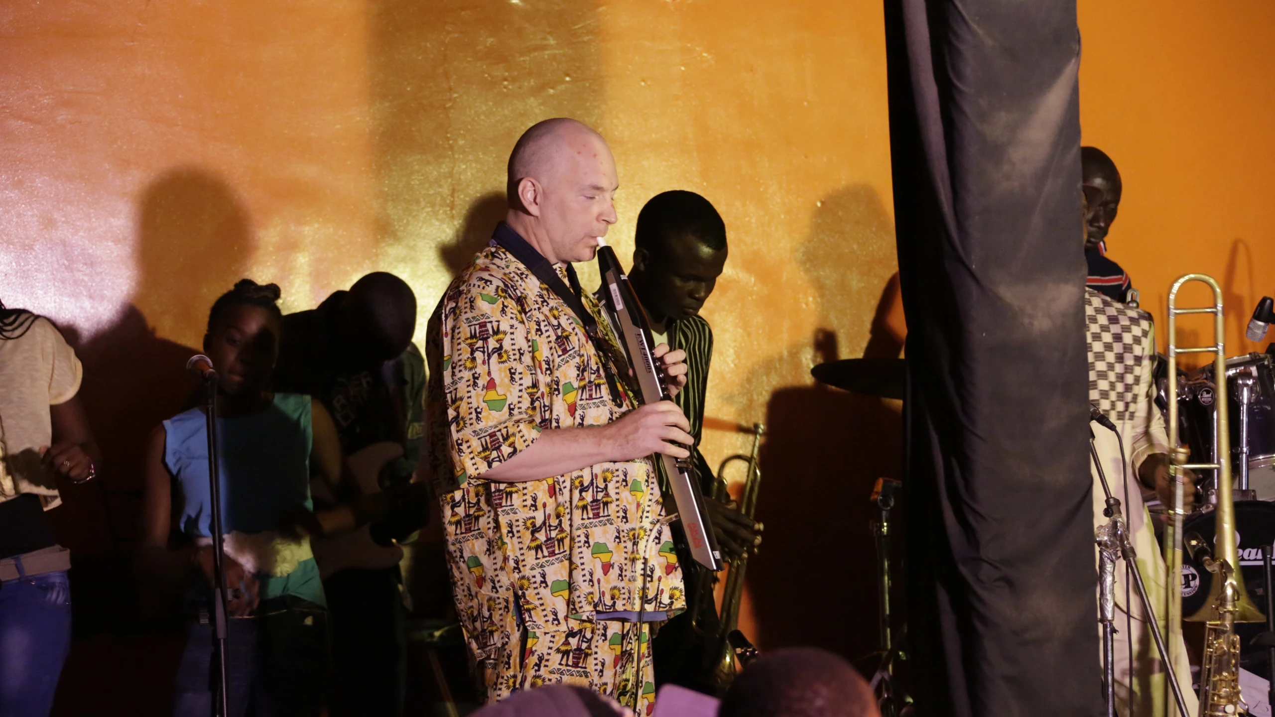 a man in an african costume stands in a large room