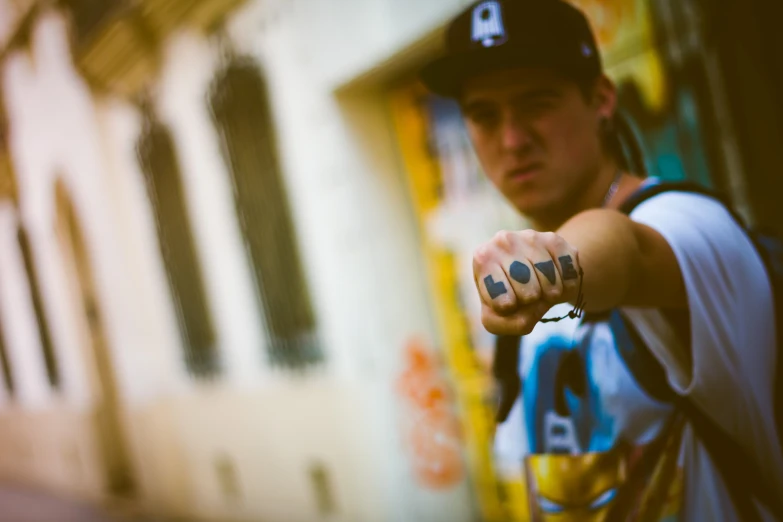 man in a baseball cap pointing soing with his left hand