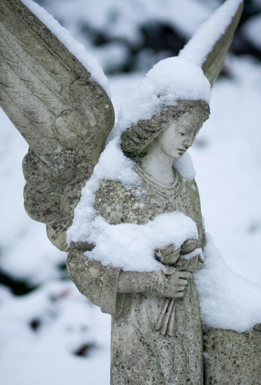 the angel statue is covered in snow with snow