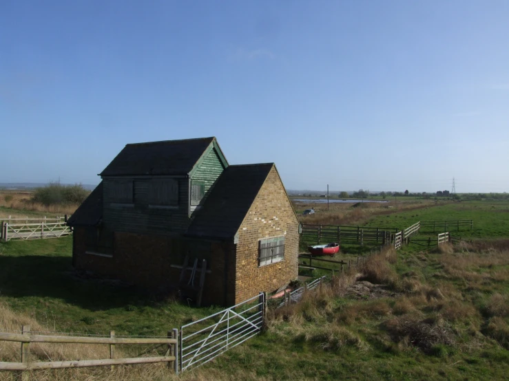 a red and black barn with a fence and a pasture