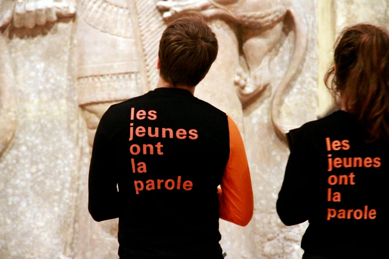 the back of the shirt shows the letters, les jeunes, ent la parcole and an old statue