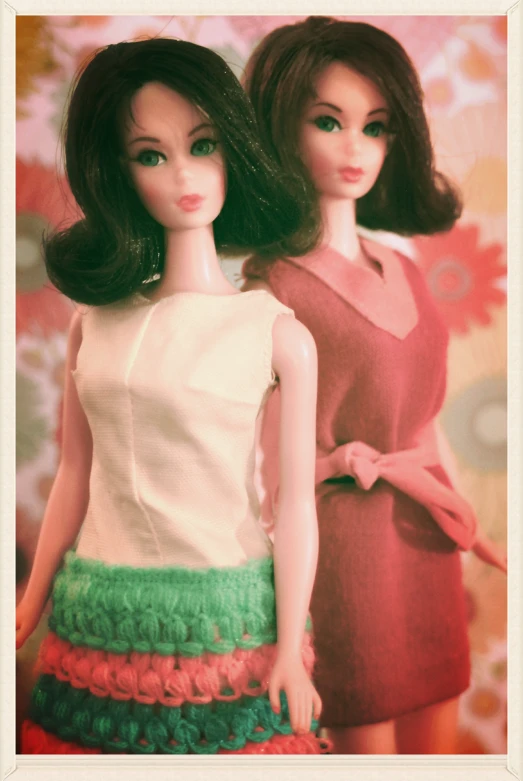 two doll dolls in dress on display with colorful floral wall