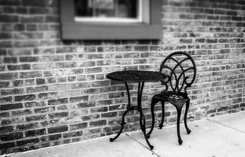 a table and chairs sitting on the side of the road near a building