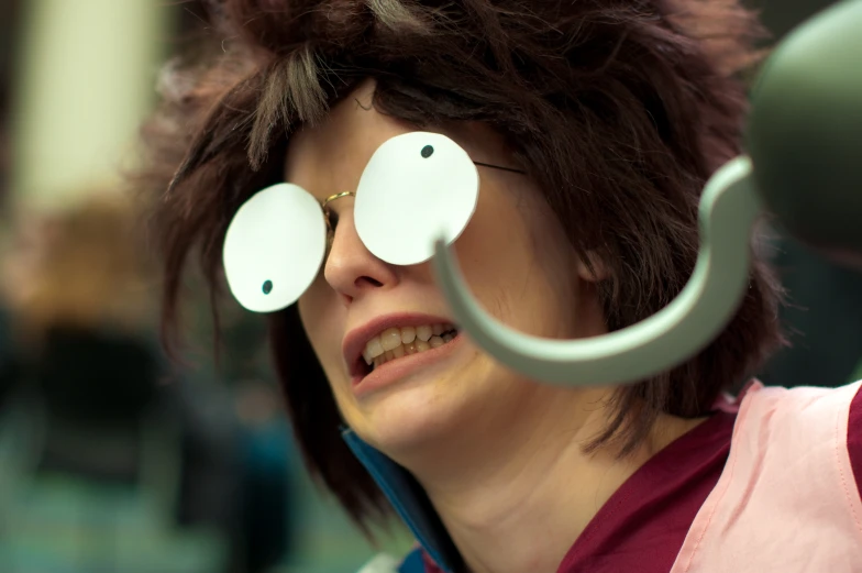 a woman standing with two circular white mirrors in her eye