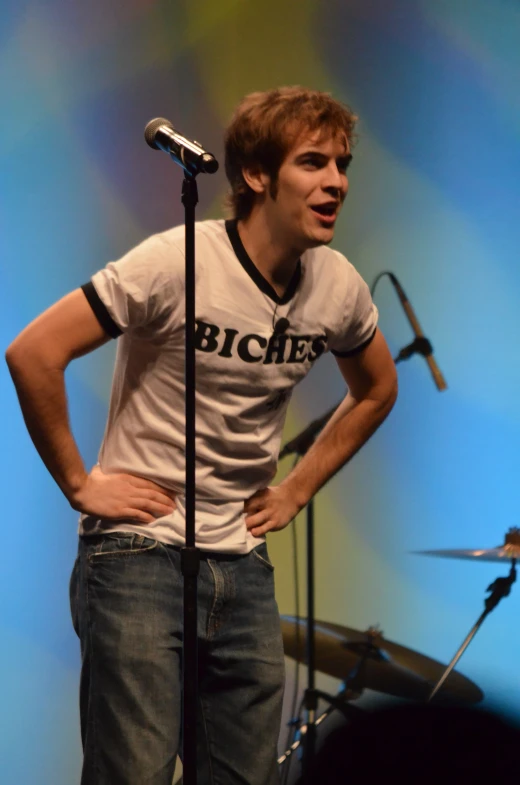 young male singer in front of microphone and mic