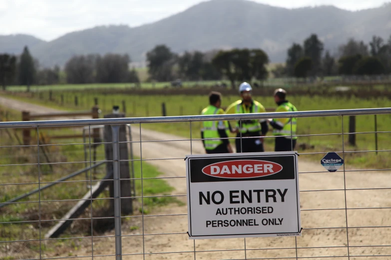 a no entry sign by the fence on a country road