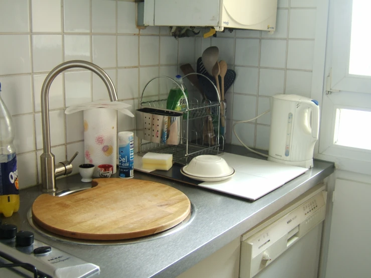 kitchen with wooden  board next to white and beige tile wall