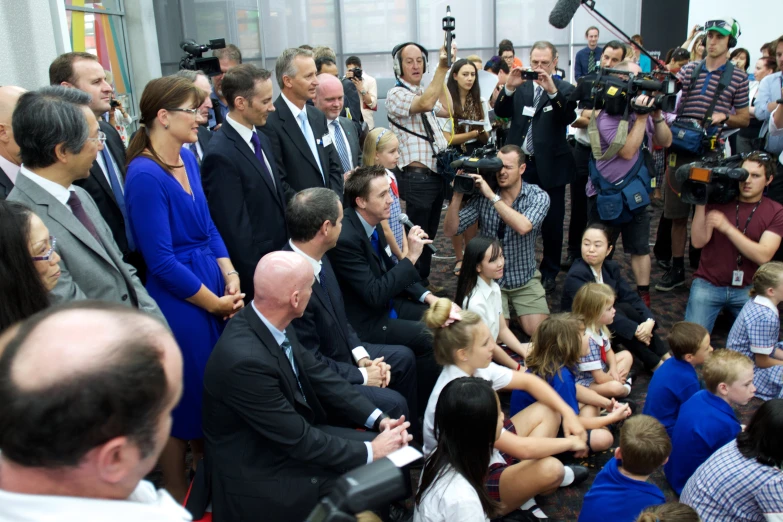 a crowd of people with cameras surrounding the woman