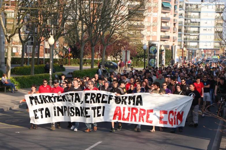 people walking with signs in the street on a sunny day