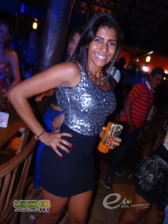 a woman in a black dress standing by the bar