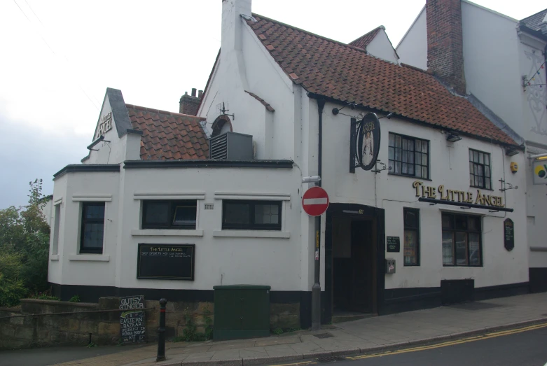 white bricked building with windows and red traffic sign in front