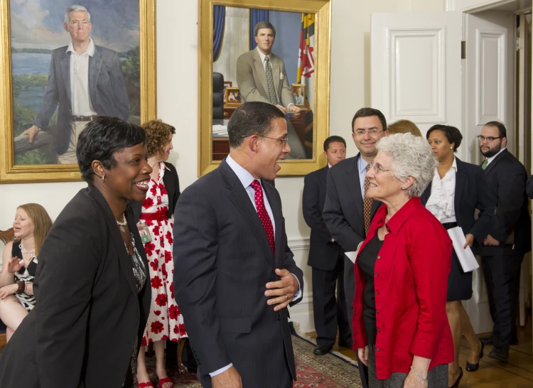 a man and women are smiling as they talk in a room