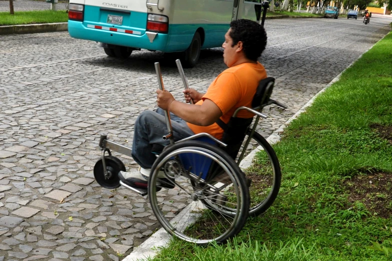 a man in a wheel chair holding two cellphones