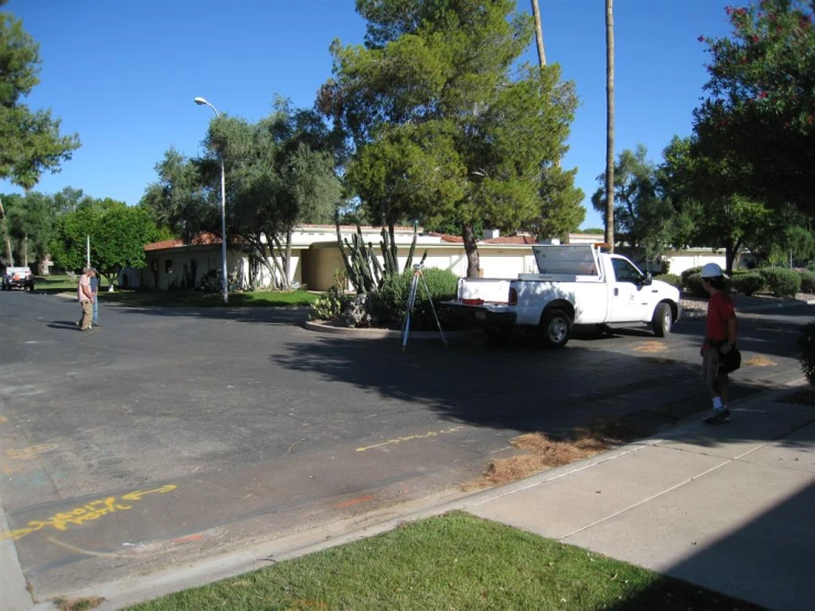 people walk past an empty lot with a truck