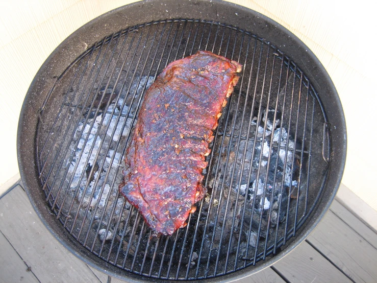 a large piece of meat is being cooked on a bbq