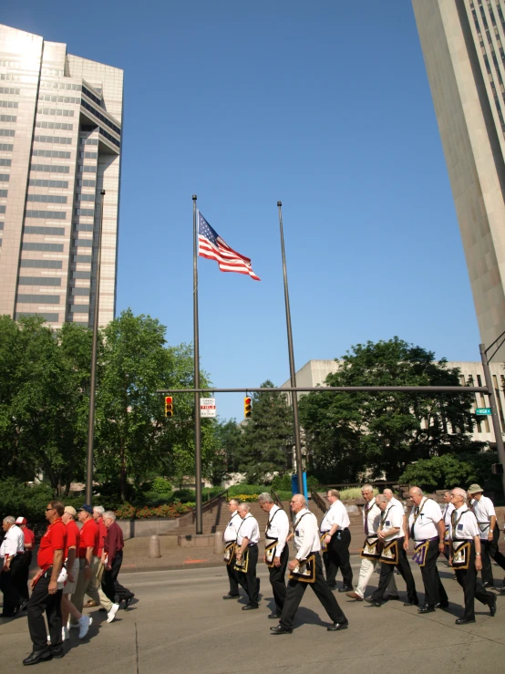 a large group of men in uniform walking together on a street