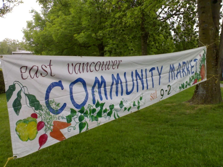 a banner is being held outside for community market