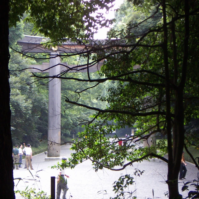 people stand near the water under a bridge