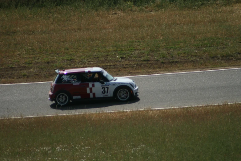 a small car is driving down a curved road