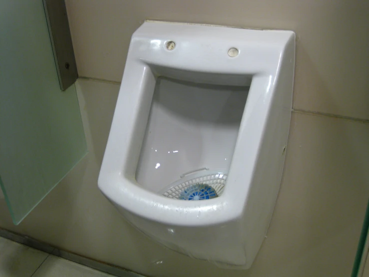 a urinal in the wall is filled with a blue and white liquid