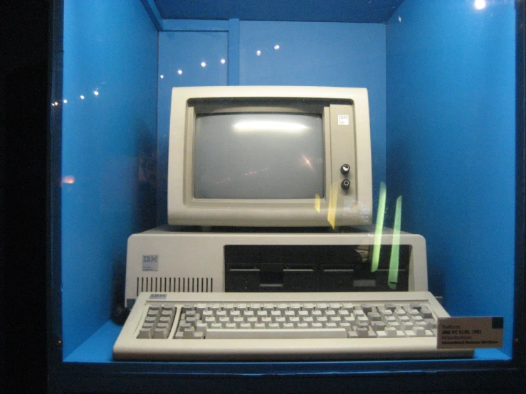 an old computer with a keyboard and monitor is on display